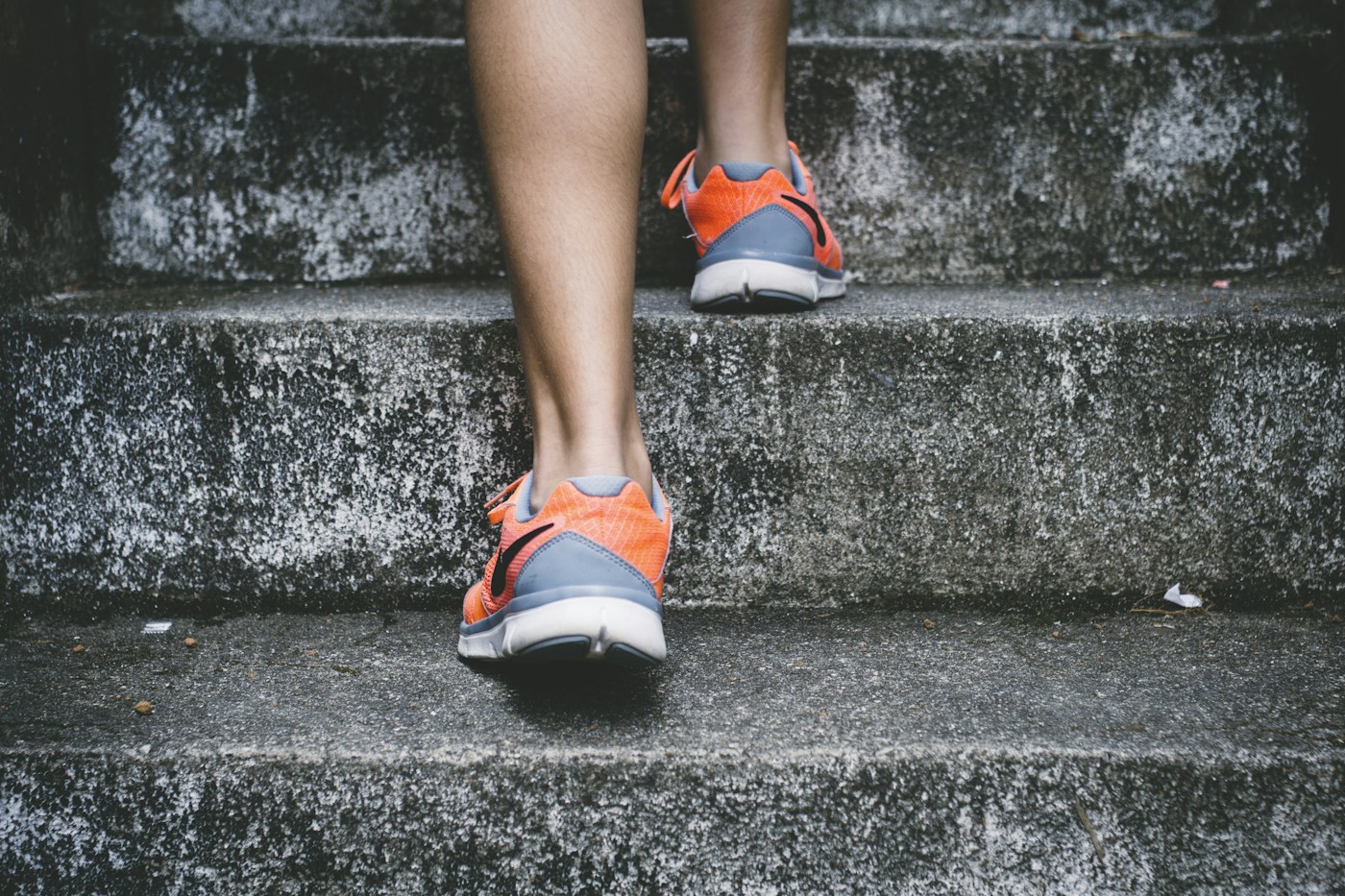 Close-up of running shoes taking a step up outdoor stairs